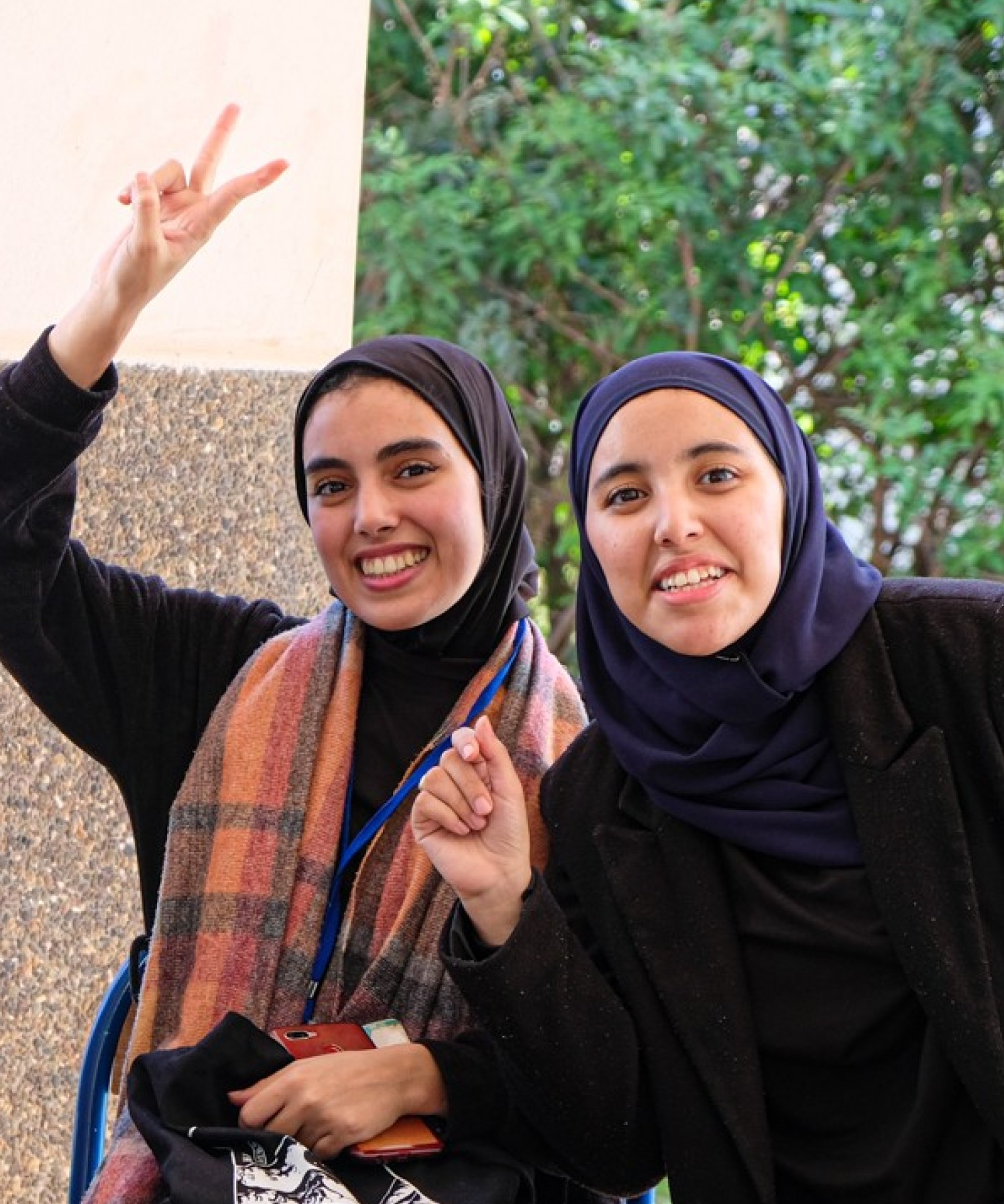 Vier junge Frauen in Marokko lachen und zeigen das Peace Zeichen mit den Fingern.