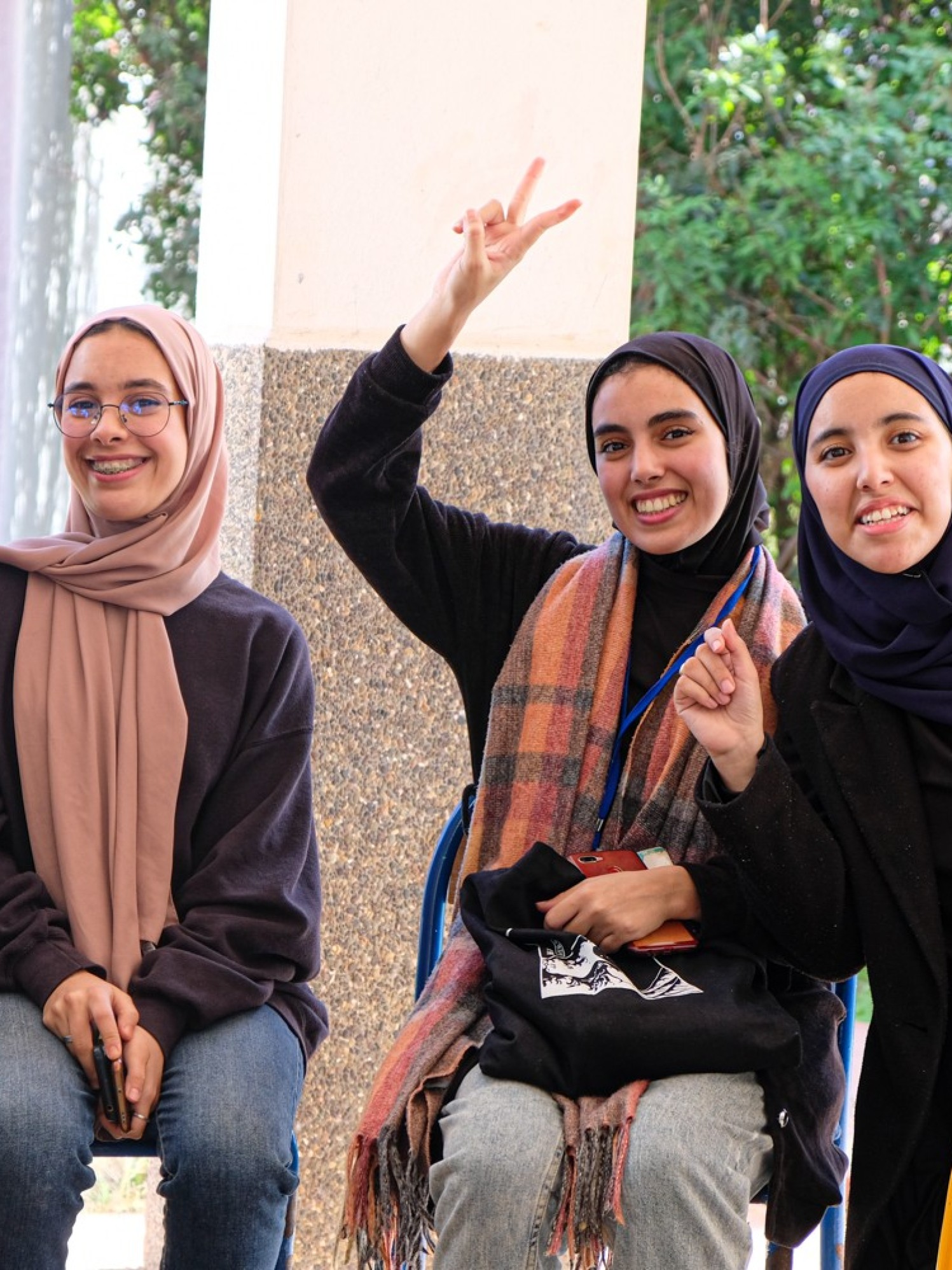 Vier junge Frauen in Marokko lachen und zeigen das Peace Zeichen mit den Fingern.